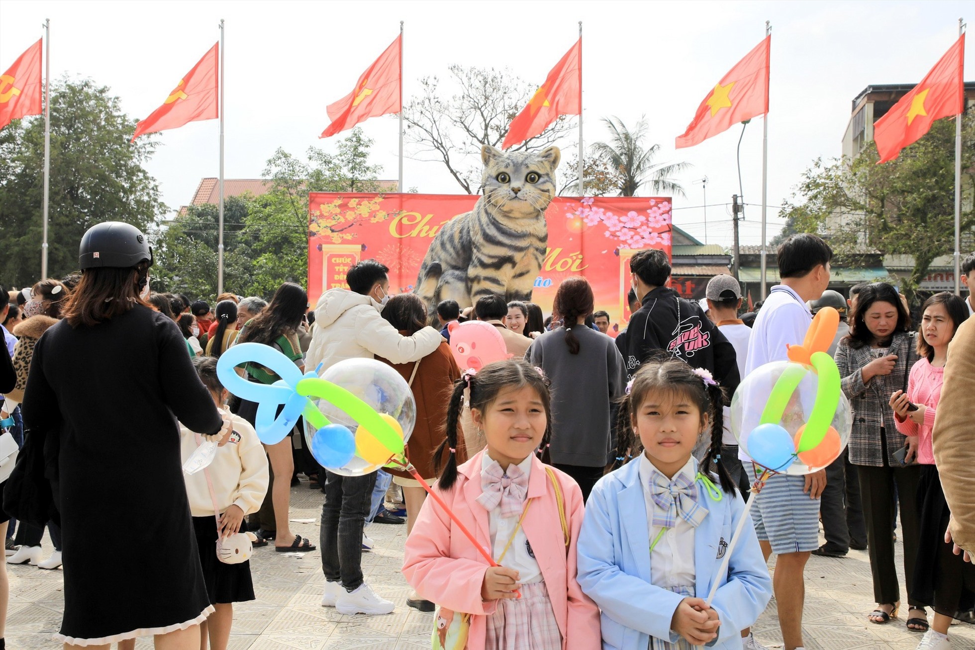 Mỗi ngày, có hàng nghìn người dân đến quảng trường. Ai cũng muốn lựa chọn cho mình góc đẹp, nhưng do lượng người đứng chen kín, nên 2 bé gái được người thân cho đứng xa tượng mèo rồi chụp đại bức ảnh, “miễn có linh vật mèo phía sau là được“.