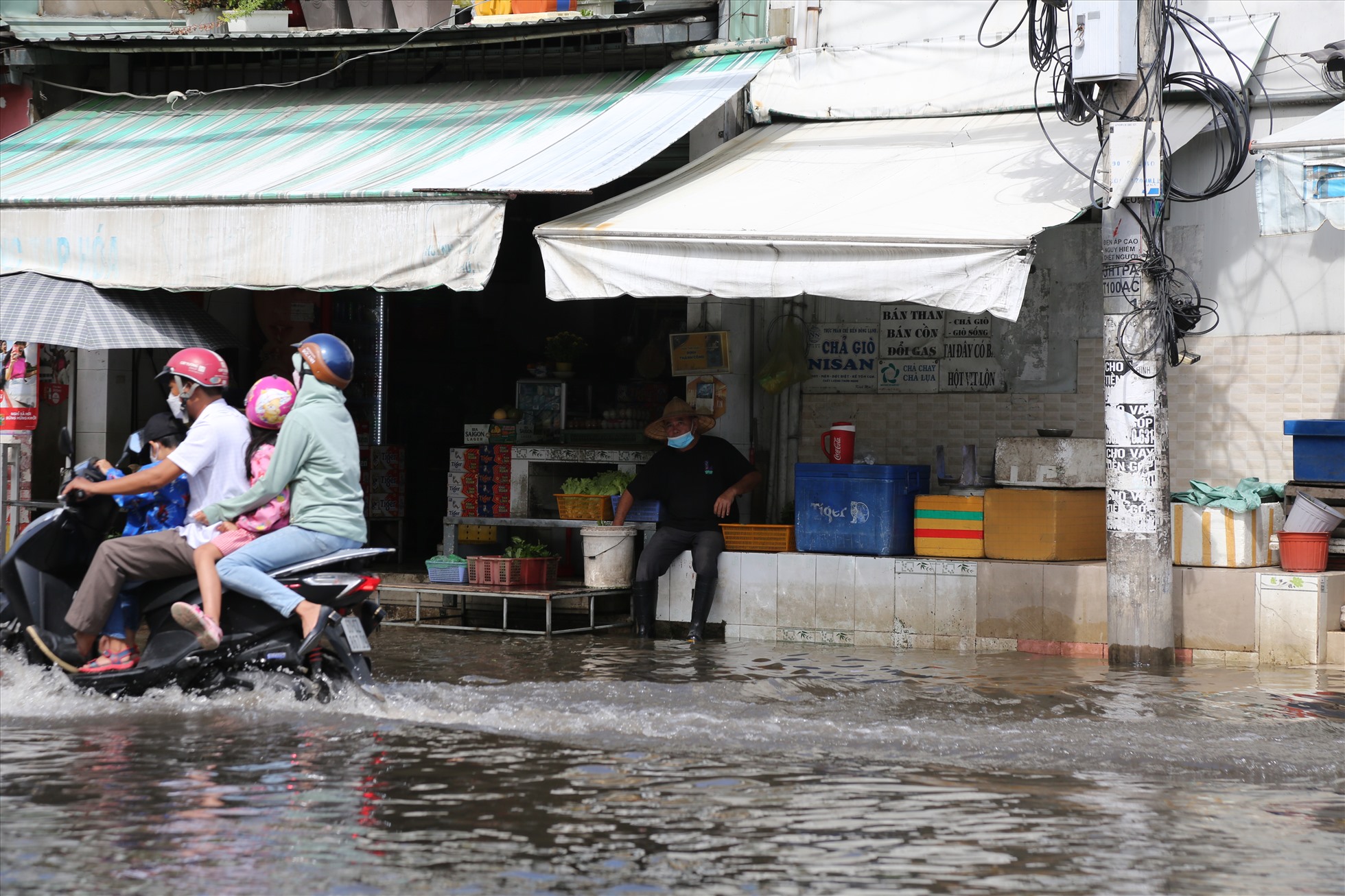Nước ngập gần nửa bánh xe, nhiều người dân phải lựa chọn đi đường vòng để tránh những con người thấp, ngập nước.
