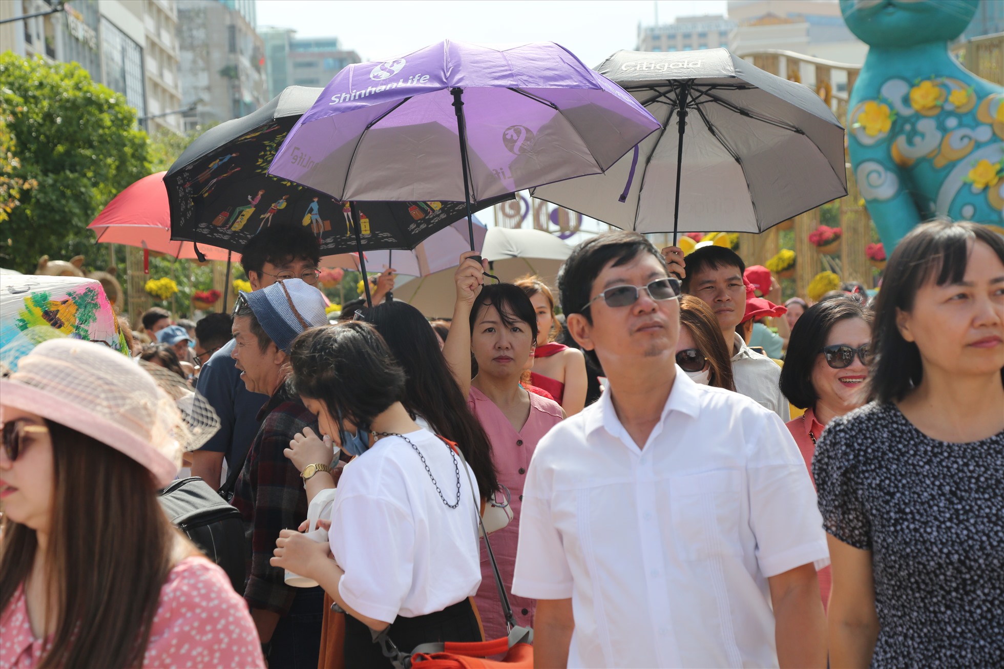 . Giữa trưa, nắng nóng nên nhiều người dân đã sử dụng dù, nón lá khi tham quan. Một số người mặc kín mít, trùm áo khoác để vui chơi.