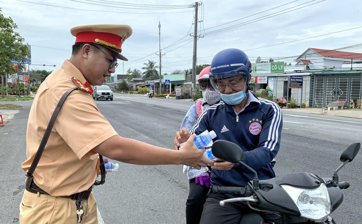 Tặng nước uống cho người dân tham gia giao thông qua địa phận tỉnh Bạc Liêu. Ảnh: Nhật Hồ