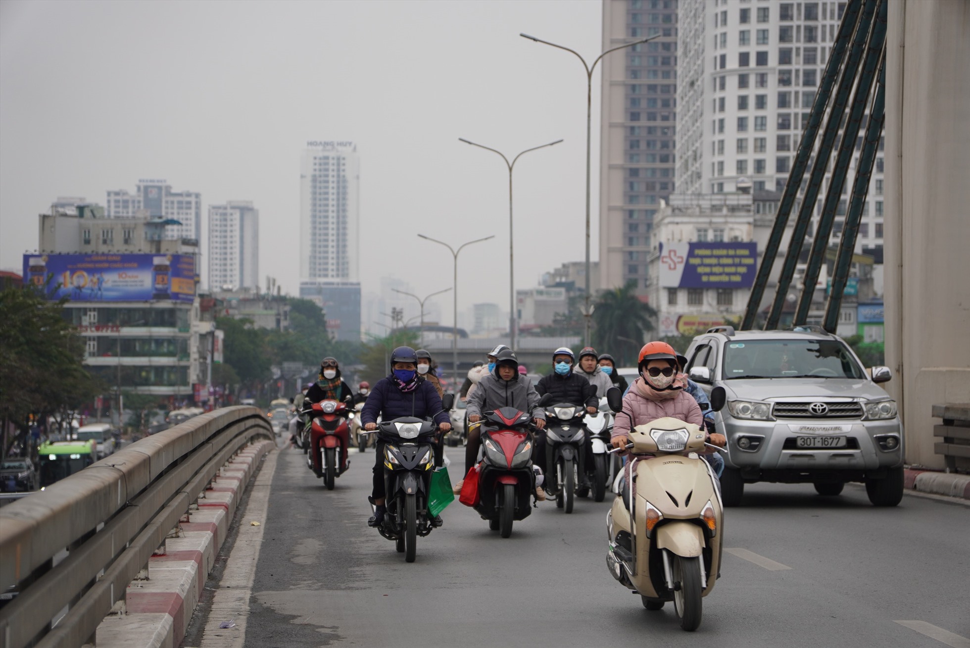 Cầu vượt Ngã Tư Sở có phần thông thoáng hơn với những tuyến đường khác. Thời tiết Hà Nội sáng nay rét buốt, một số người trang bị thêm găng tay, khăn và áo ấm để tránh gió lạnh. Ảnh: Hữu Chánh