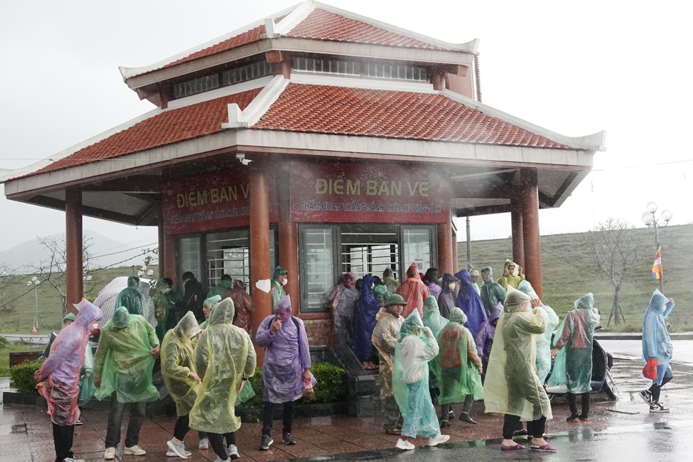 Nhiều du khách vẫn mua vé lên chùa mặc cho trời mưa. Ảnh: Trần Tuấn.