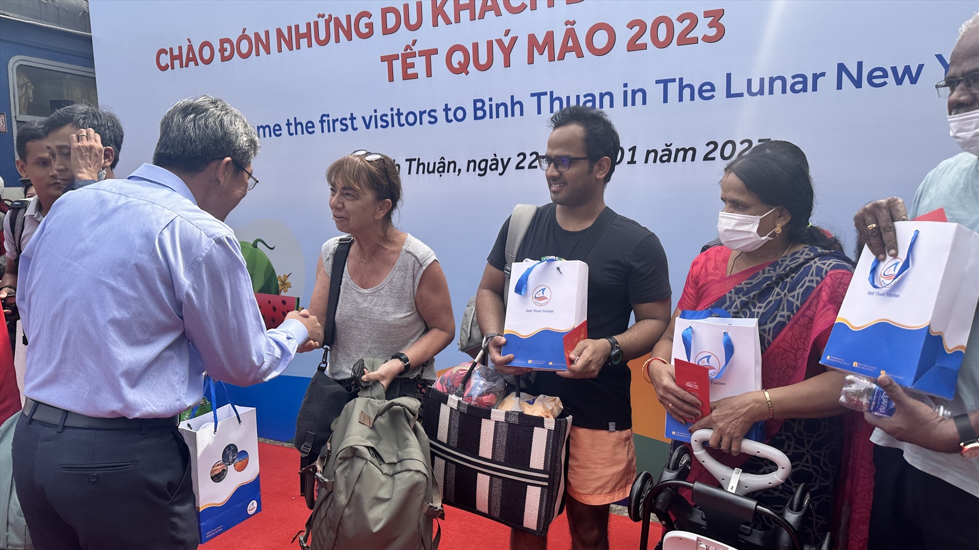 Lãnh đạo UBND tỉnh Bình Thuận lì xì, chúc Tết các du khách đầu tiên xông đất Bình Thuận sáng mùng 1 Tết. Ảnh: Duy Tuấn
