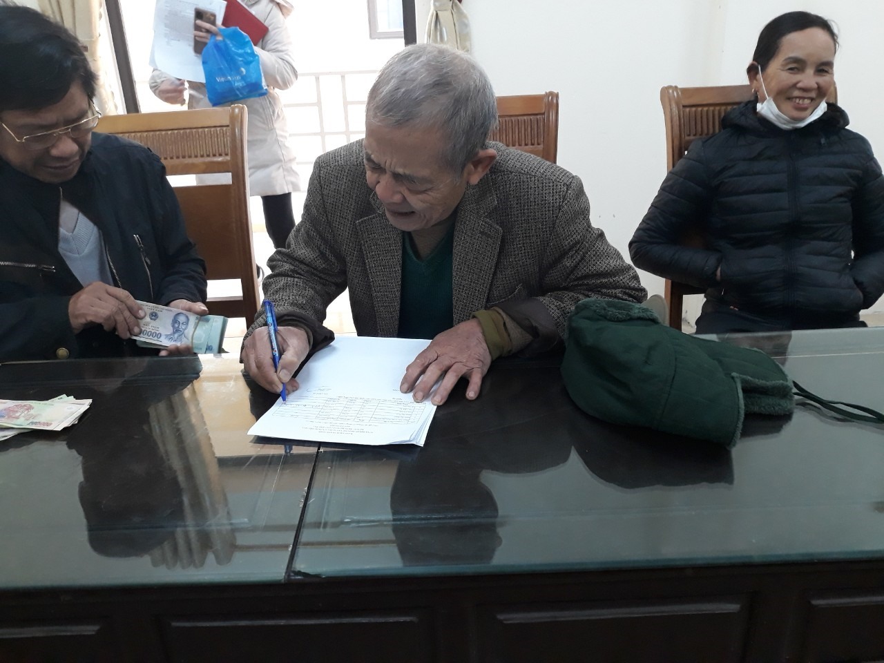 Người dân ký nhận tiền hỗ trợ tại UBND xã Ninh Khang. Ảnh: Diệu Anh