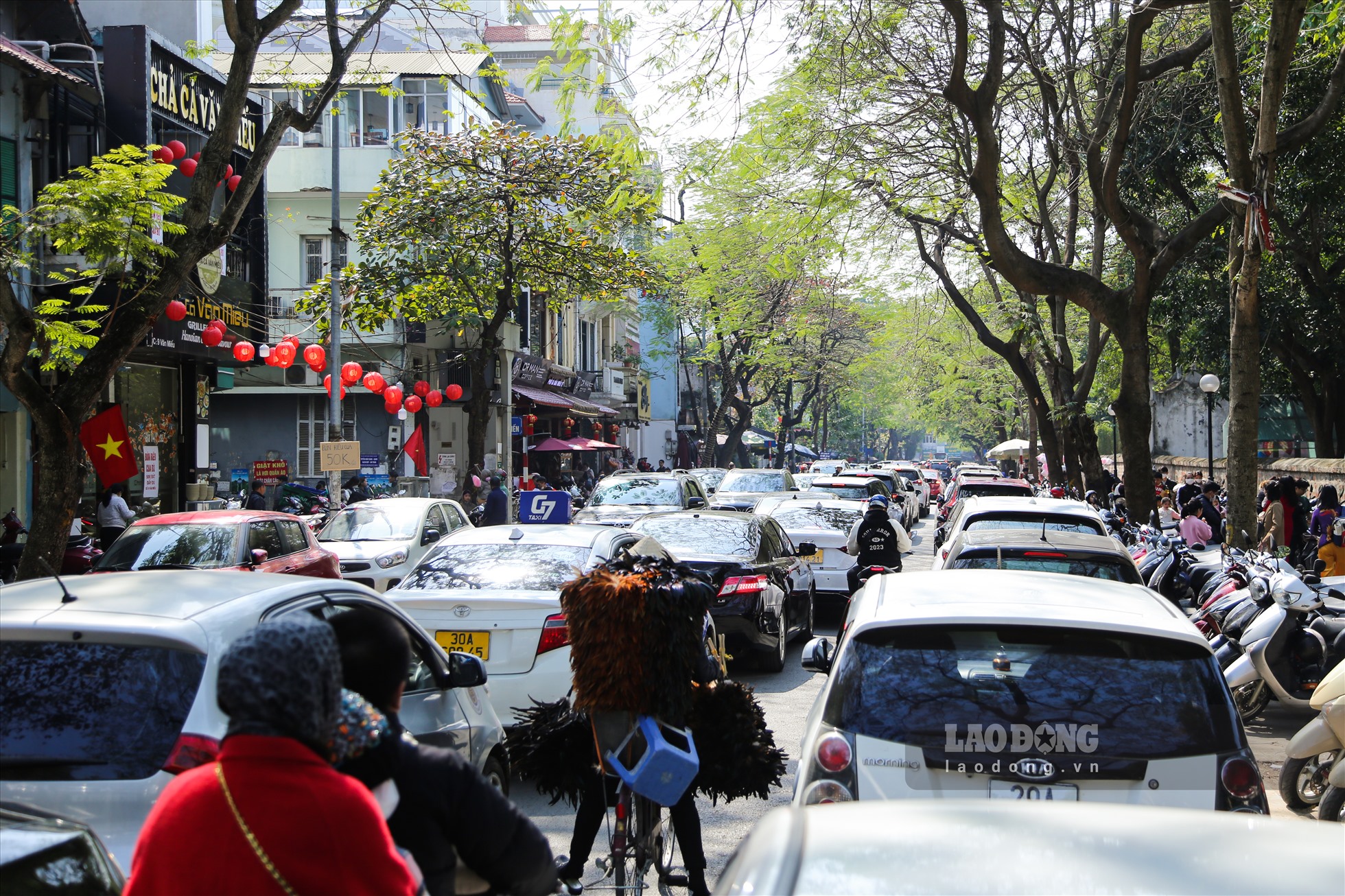 Tại phố Văn Miếu, các phương tiện di chuyển khó khăn do một phần làn đường đã trở thành nơi để xe ô tô.