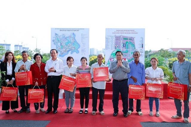 Thủ tướng Phạm Minh Chính và Bí thư Thành ủy TPHCM Nguyễn Văn Nên tặng quà cho bà con nhân dân khu tái định cư dự án.  Ảnh: VGP/Nhật Bắc