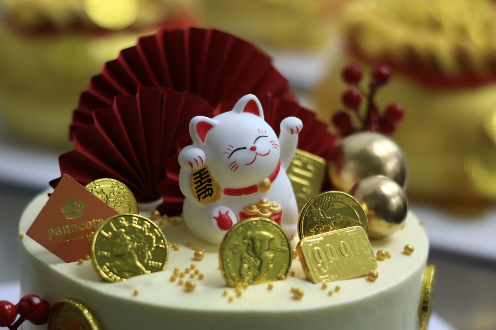 Bánh được đính thêm nhiều đồng tiền làm từ sôcôla, tượng Thần Tài hoặc mèo may mắn. Ảnh: Nguyễn Thúy.