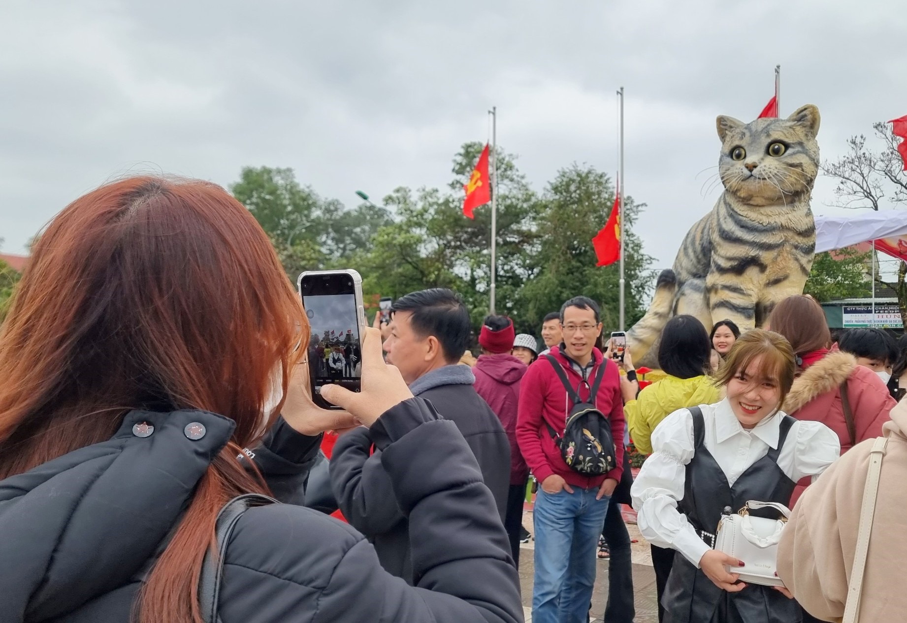 Người dân đến chụp ảnh kỷ niệm với linh vật mèo trong những ngày Tết. Ảnh: Hưng Thơ.