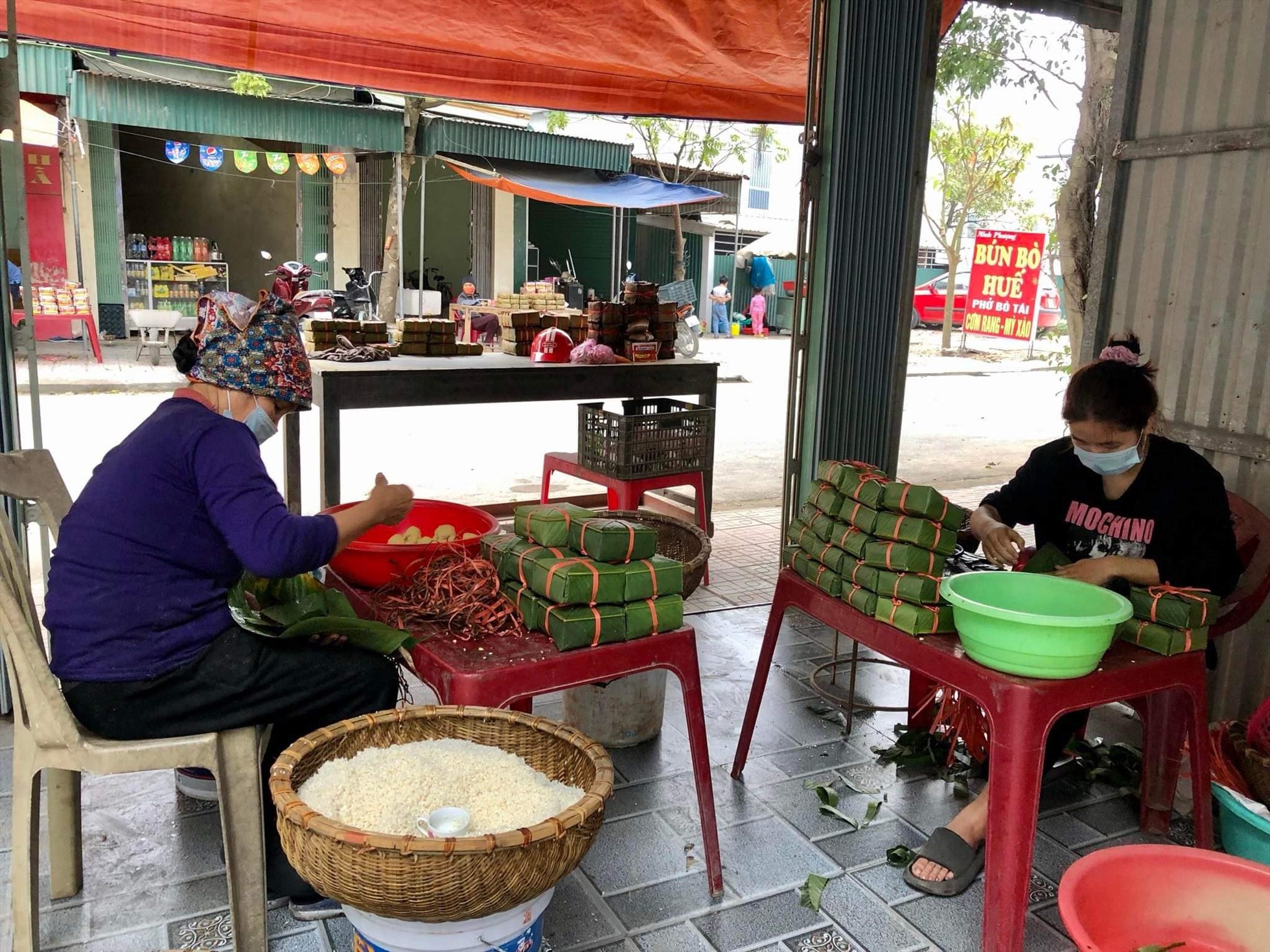 Bà Nguyễn Thị Huệ (sinh năm 1968, vợ ông Vũ Đình Phôi) luôn chân, luôn tay vừa bán bánh vừa gói bánh mới. Ảnh: Trung Du