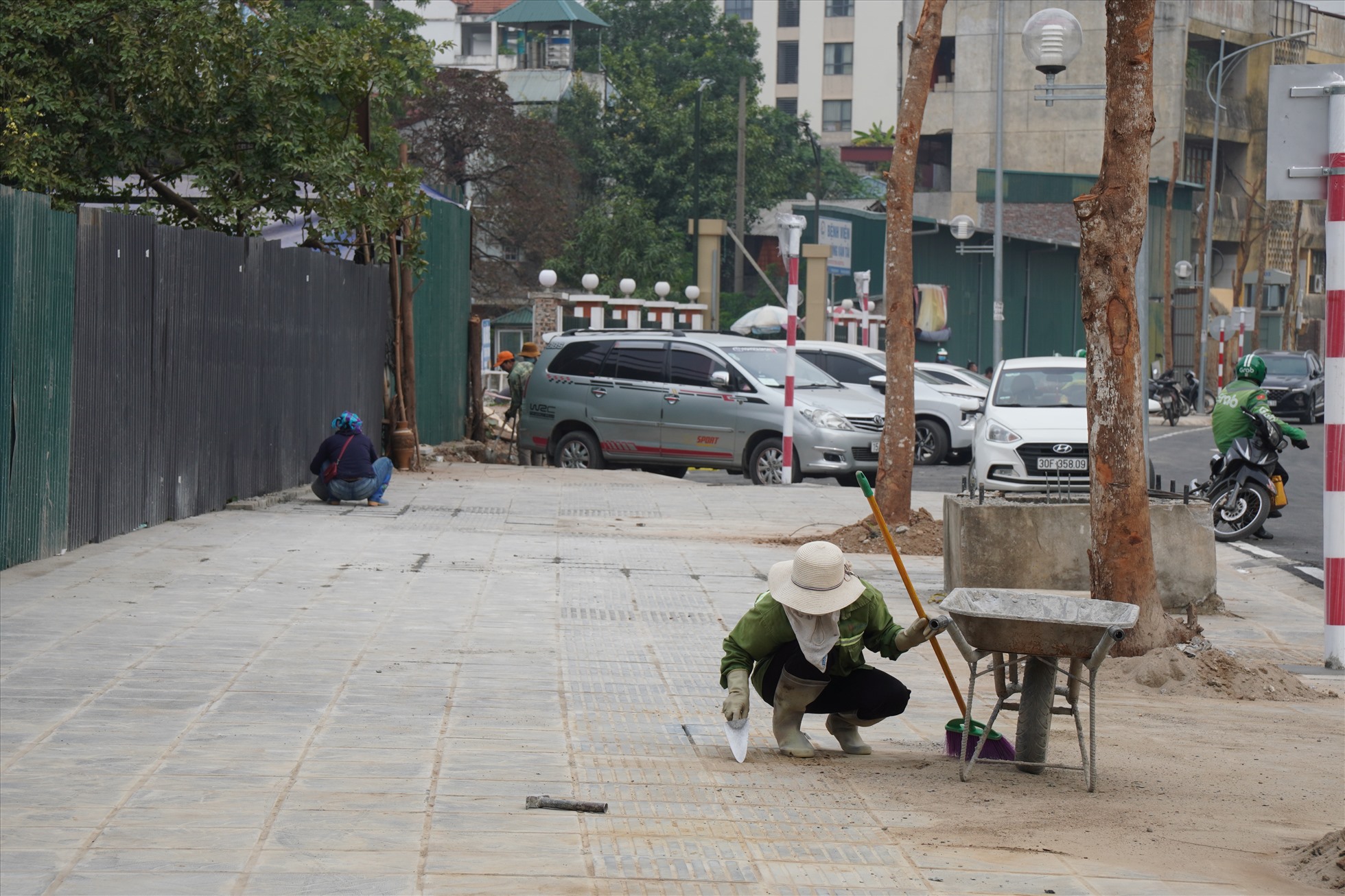 Nhóm công nhân đang dọn dẹp vỉa hè.  Ảnh: Hữu Chánh