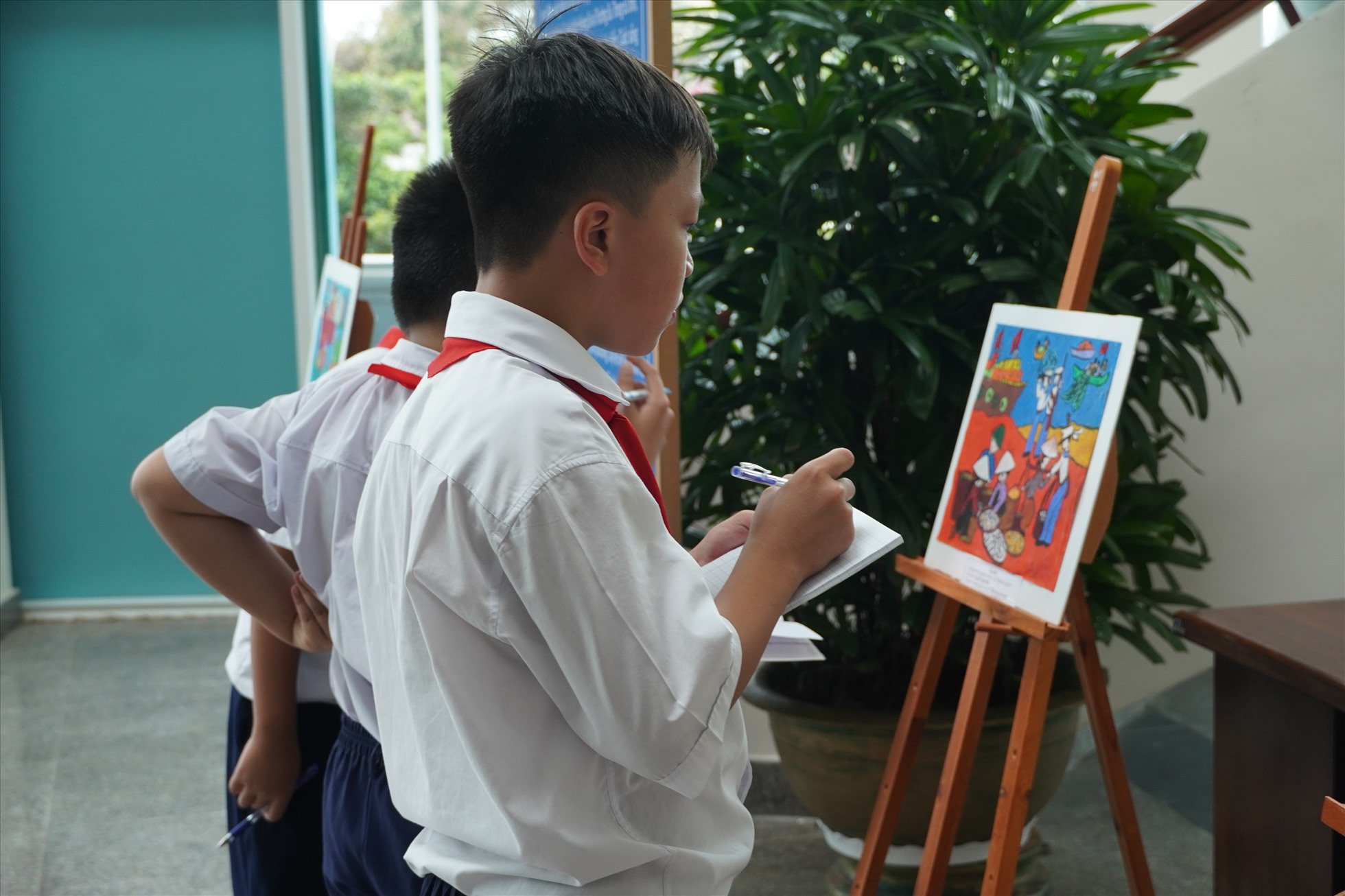 Một số học sinh đang tham quan các bức tranh đạt giải tại cuộc thi vẽ theo chủ đề “Biển đảo quê hương“. Ảnh: Thành An