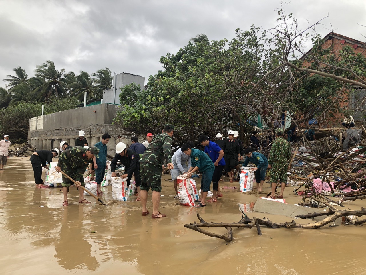 100 cán bộ chiến sĩ được huy động hỗ trợ người dân 3 xã ven biển huyện Tuy An ứng phó với triều cường, mưa lớn. Ảnh: Nguyễn Linh