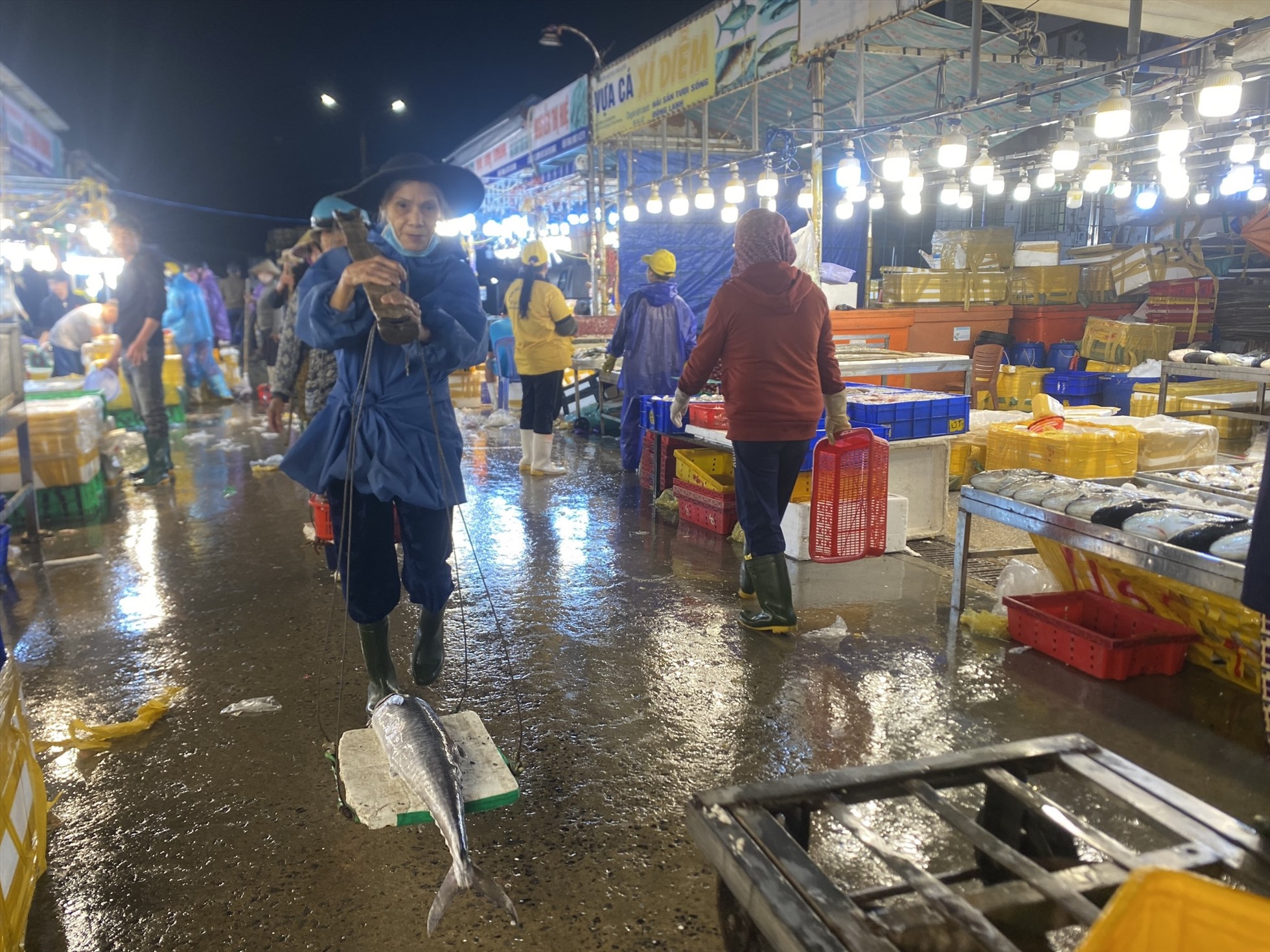 Những người làm nghề gánh cá thuê tại cảng cá Thọ Quang. Ảnh: Văn Trực