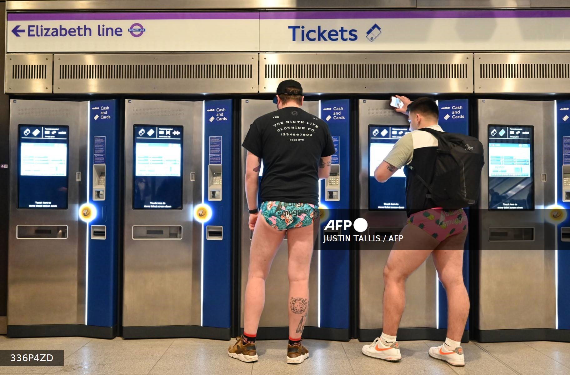 Hành khách tham gia “Ngày không mặc quần” trên tàu điện ngầm London mua vé tàu, ngày 8.1.2023. Ảnh: AFP