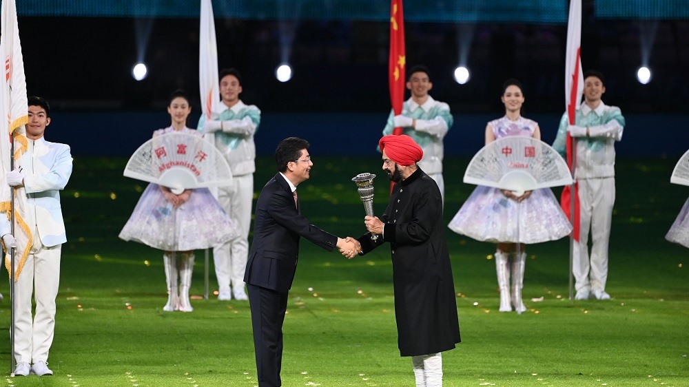 Chủ nhà ASIAD 20 Nhật Bản (trái) nhận ngọn đuốc của Đại hội từ tay Chủ tịch Ủy ban Olympic châu Á (OCA) Raja Randhir Singh.