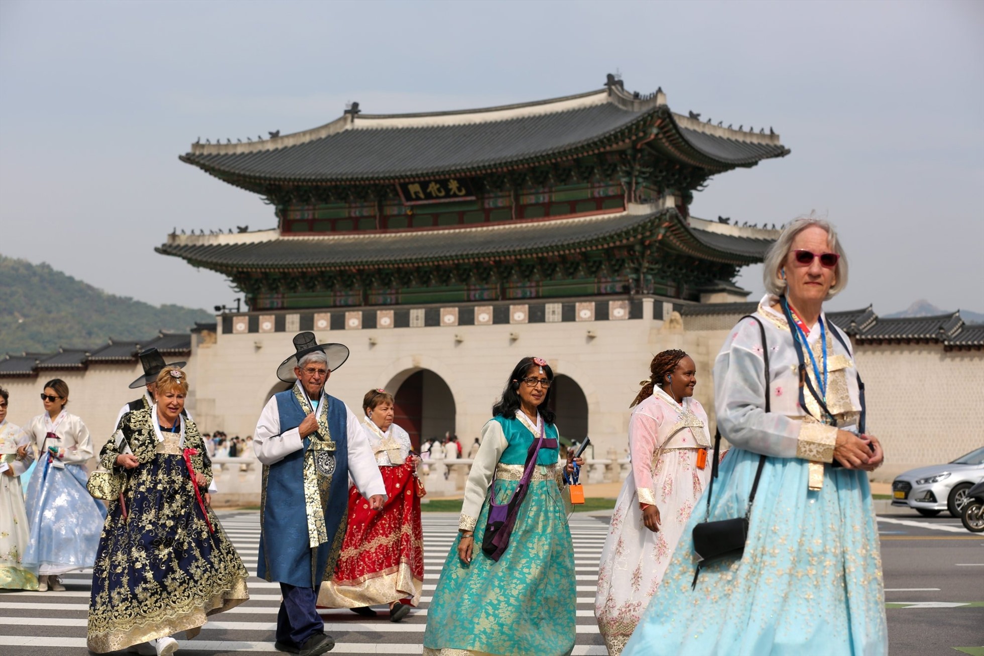 Khách du lịch mặc hanbok truyền thống băng qua đường gần Gwanghwamun, cổng lớn nhất của Cung Cảnh Phúc ở Seoul, Hàn Quốc. Ảnh: Tân Hoa Xã