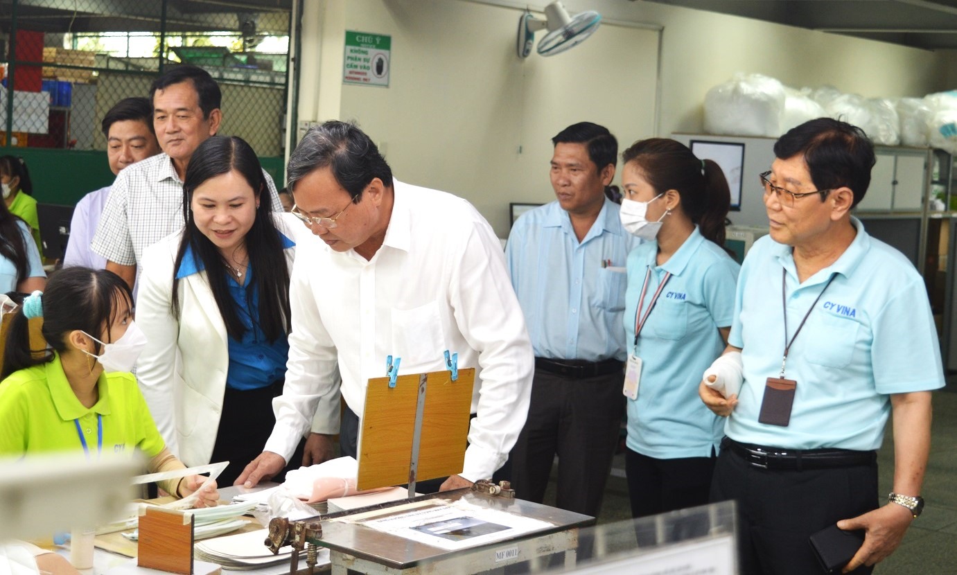 Chủ tịch UBND tỉnh Lê Văn Hẳn (phải) thăm hỏi công nhân làm việc tại Công ty TNHH MTV CY Vina. Ảnh: Trí Dũng