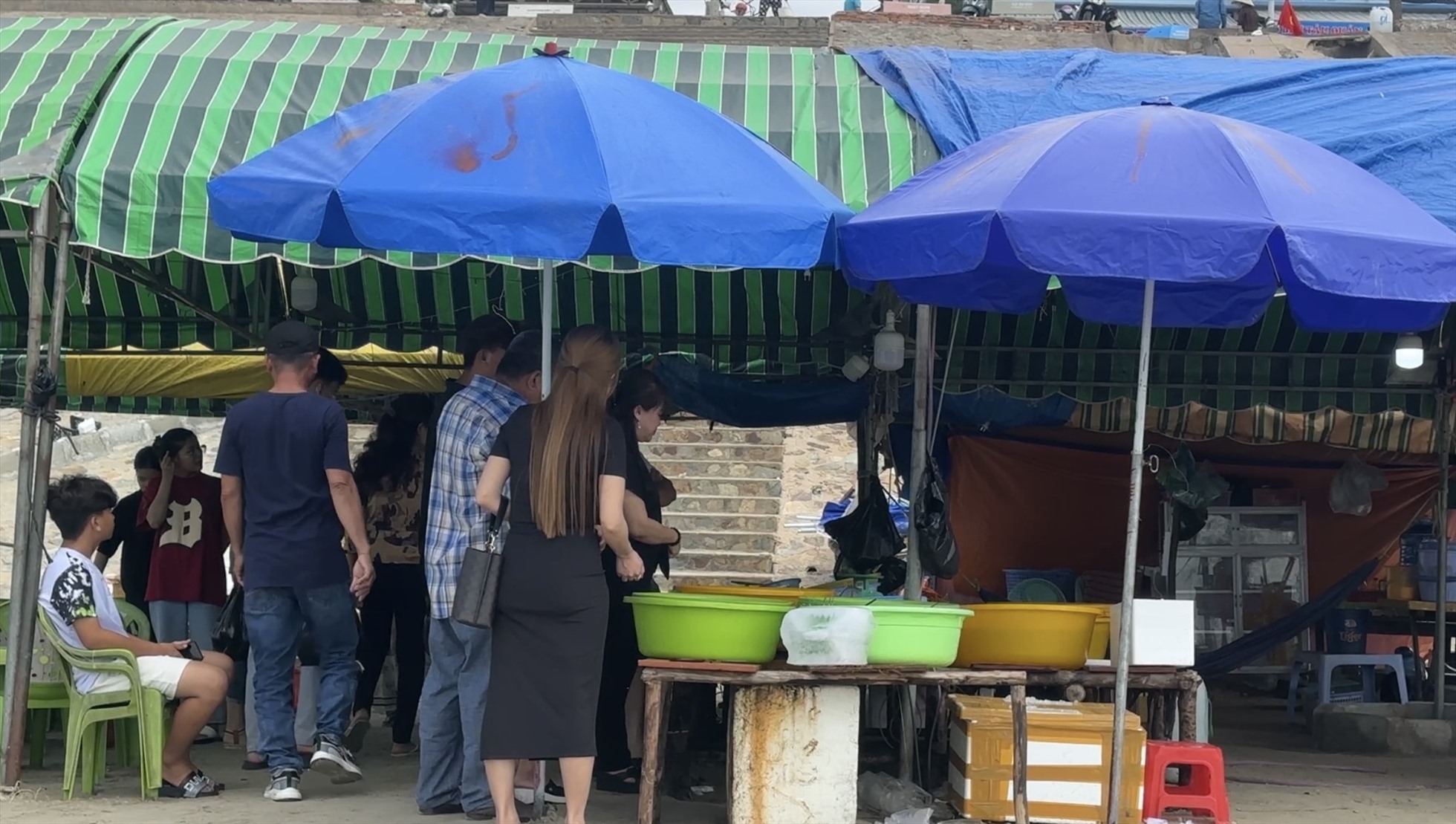 Du khách mua hải sản về làm quà ở bờ kè Làng Chài Mũi Né. Ảnh: Duy Tuấn