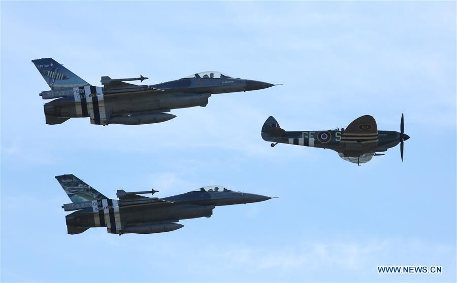Hai máy bay chiến đấu F-16 của Không quân Bỉ tháp tùng chiếc “Spitfire” cổ - loại máy bay chiến đấu nổi tiếng trong Thế chiến II - trong màn trình diễn nhào lộn tại Triển lãm Hàng không Sanicole Quốc tế ở Hechtel, Bỉ, ngày 15.9.2019. Ảnh: Xinhua