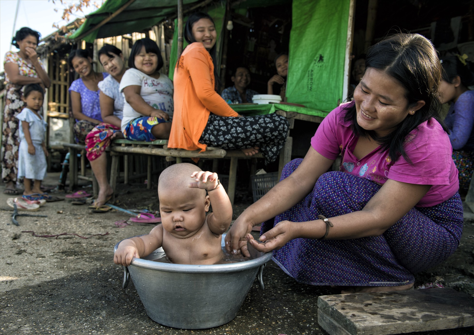 Tắm mát cho con (tại một khu ổ chuột ở Yangon, Myanmar).
