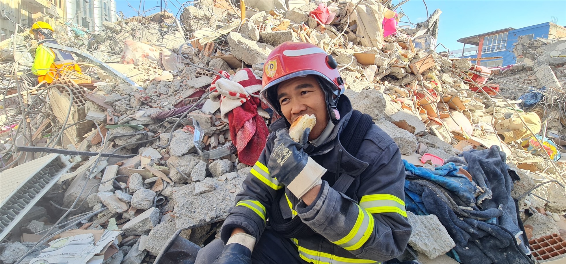 Công an Việt Nam ăn vội bánh mì tại hiện trường toà nhà đổ nát. Ảnh: Cục Cảnh sát PCCC&CNCH