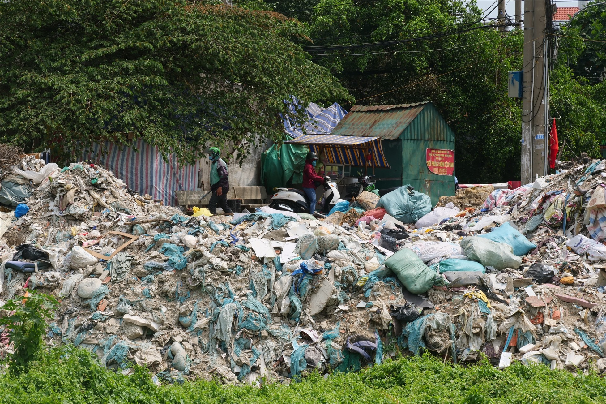 Theo ghi nhận của phóng viên, dọc hai bên dòng kênh được người dân địa phương “lén” tập kết rác thải. Bên cạnh đó, nhiều khối lượng xà bần, phế thải bị đổ trộm đã tràn xuống cả dòng kênh.