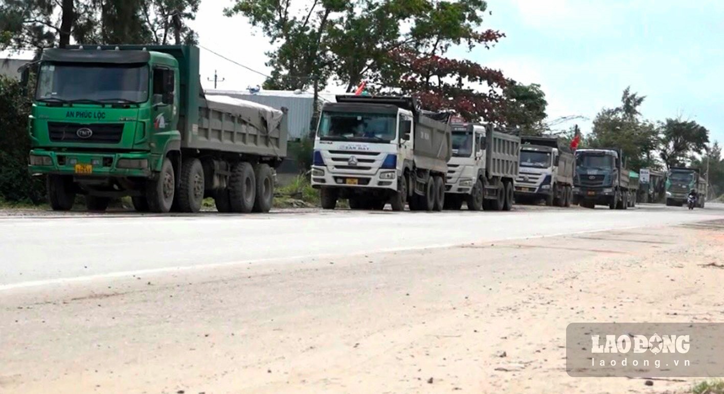Từng đoàn xe tải chở đất đá nối đuôi nhau chạy qua tuyến Quốc lộ 24C đoạn qua xã Bình Thuận, huyện Bình Sơn. Ảnh: Ngọc Viên