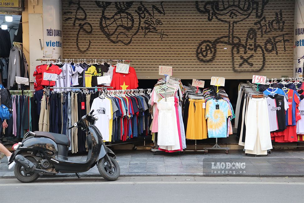 Trên phố hàng Ngang, các sạp quần áo được các hộ kinh doanh kéo tràn ra vỉa hè làm chỗ buôn bán.