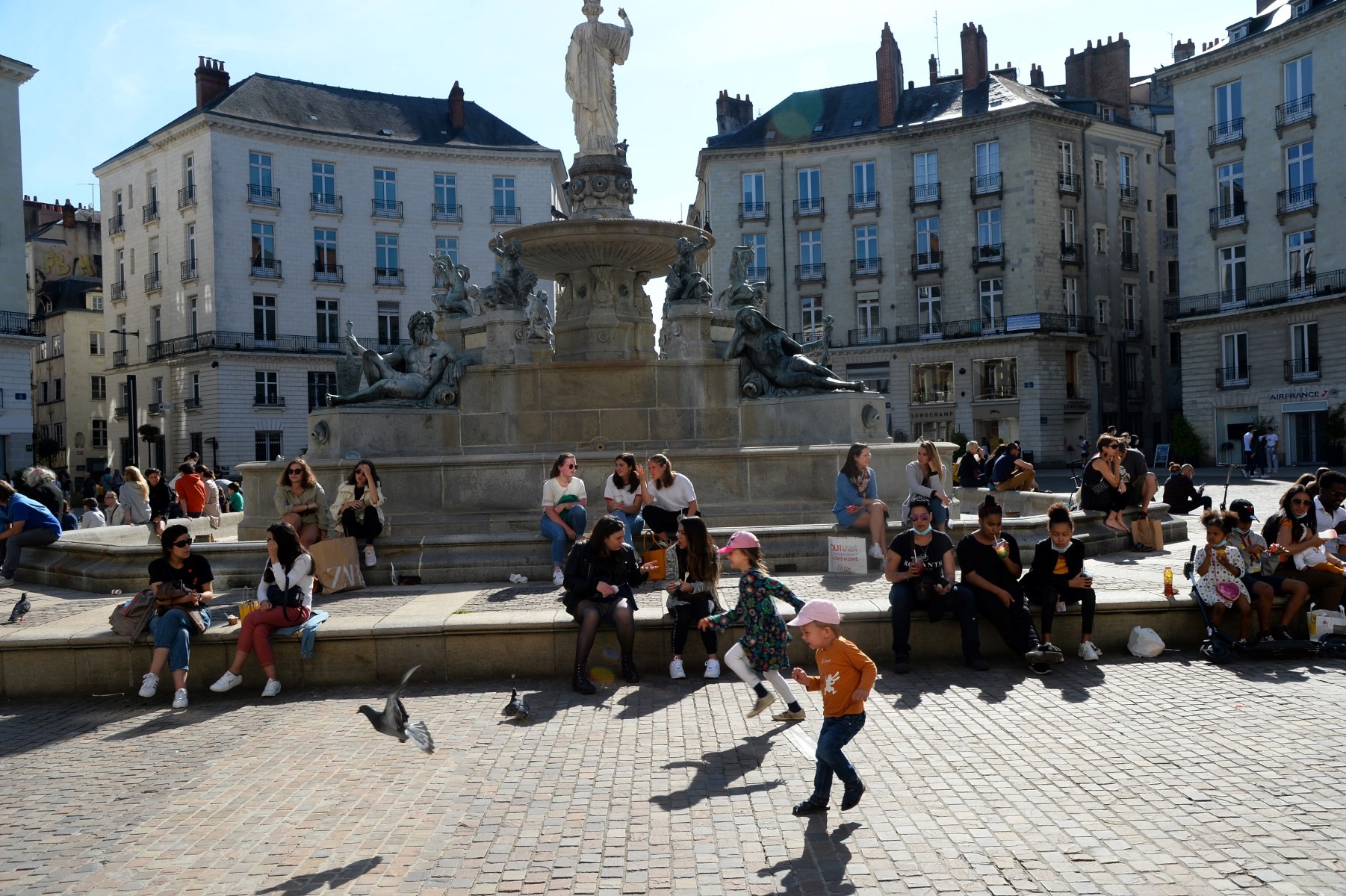 Người dân tận hưởng ánh mặt trời trước đài phun nước tại Place Royale, ở Nantes, miền tây nước Pháp, ngày 16.5. Ảnh: AFP