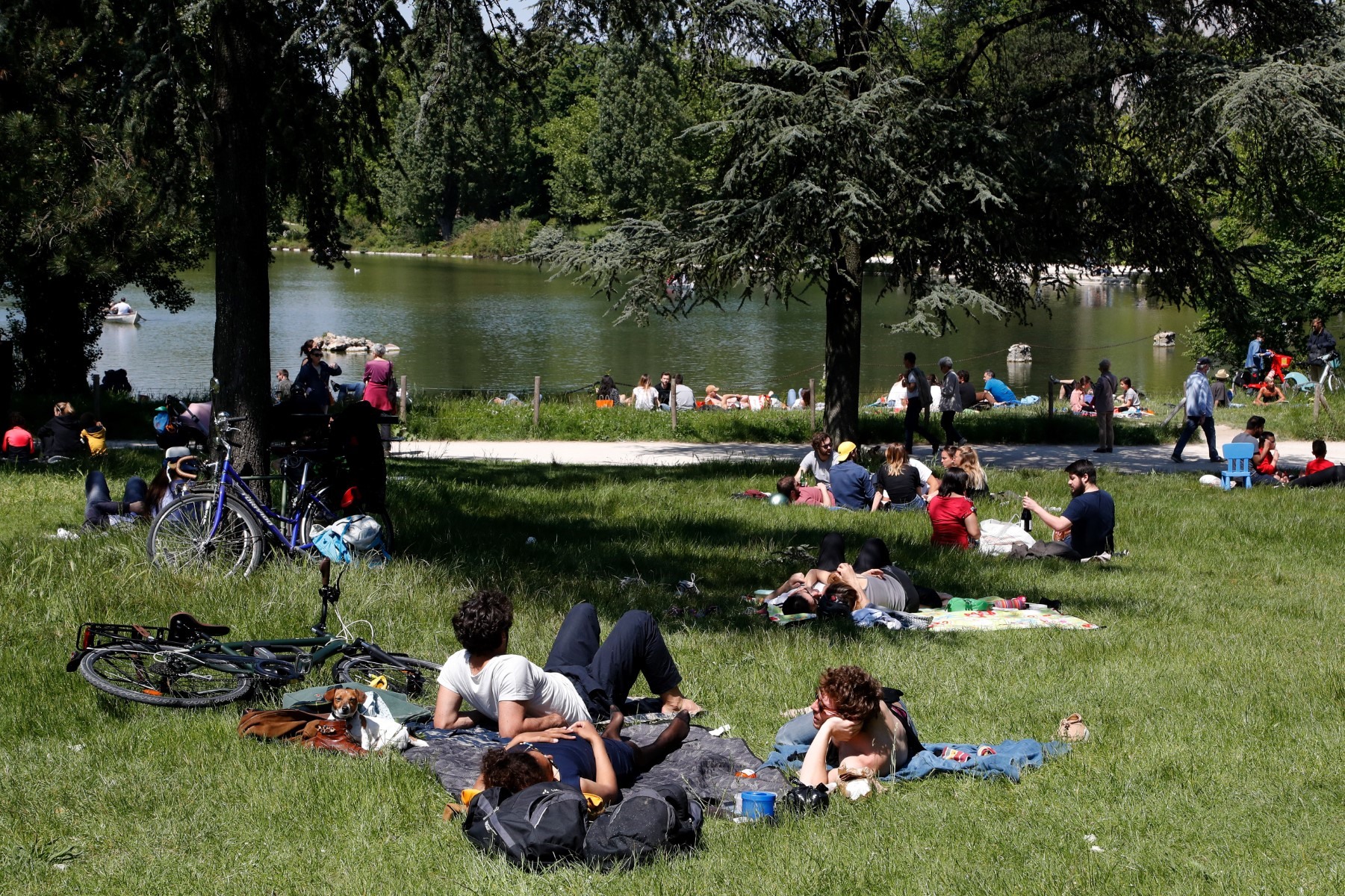 Người dân đổ ra ngoài chèo thuyền và vui chơi trên bãi cỏ tại hồ Dausmenil trong rừng Vincennes ở Paris, ngày 17.5. Ảnh: AFP