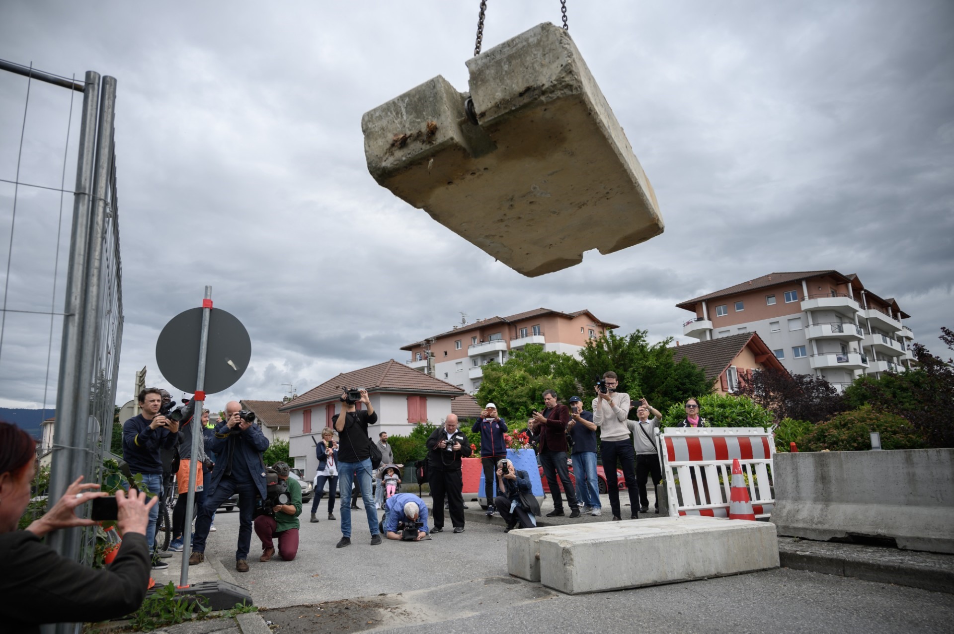 Người dân và nhà báo chứng kiến khối bê tông ngăn cách biên giới Pháp - Thụy Sĩ được dỡ bỏ hôm 14.5 tại Thonex, Thụy Sĩ, gần Ambily, Pháp. Ảnh: AFP