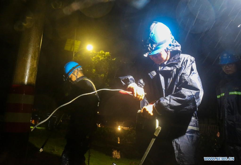 Công nhân sửa điện giữa thời tiết mưa bão ở thành phố Chu Sơn, Chiết Giang, Trung Quốc. Ảnh: Xinhua
