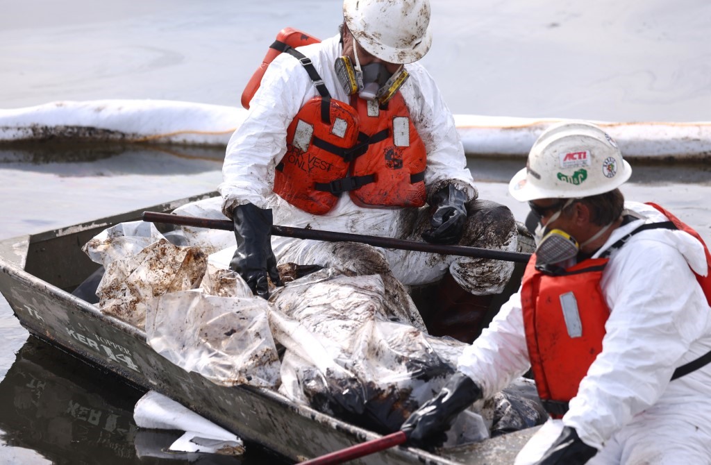 Nhân viên bảo vệ môi trường đang dọn dẹp bãi biển ở Nam California sau sự cố hơn 545.000 lít dầu rò rỉ ra môi trường biển. Ảnh: AFP