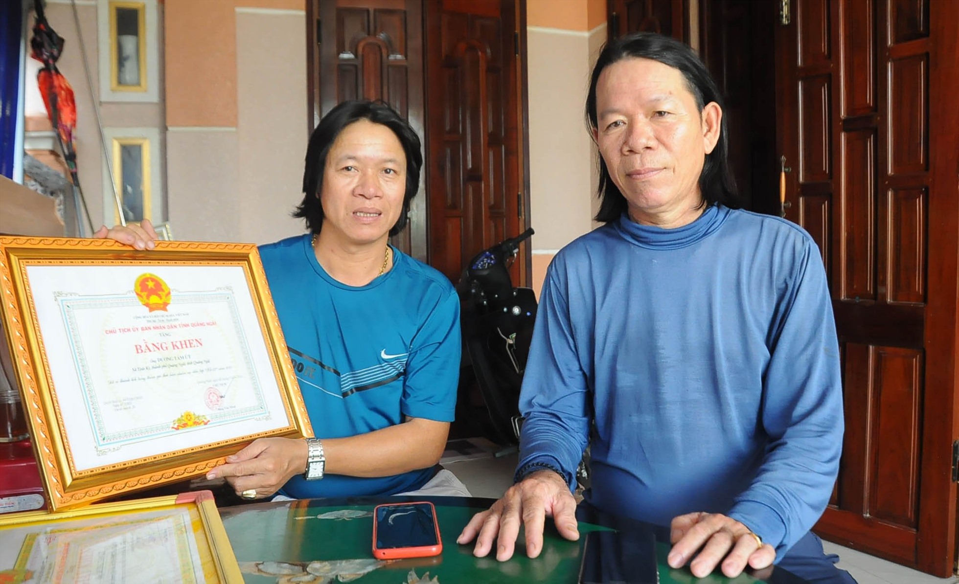 Anh Dương Tám Út (bên trái) và anh Dương Văn Xí cùng Bằng khen của Chủ tịch UBND tỉnh Quảng Ngãi. Ảnh: Ngọc Viên