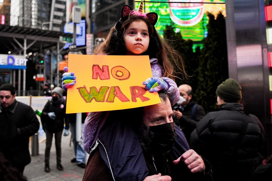Một đứa trẻ cầm biểu ngữ phản đối chiến tranh trong một cuộc biểu tình tại Quảng trường Thời đại ở New York, Mỹ, ngày 14.1.2023. Ảnh: Tân Hoa Xã