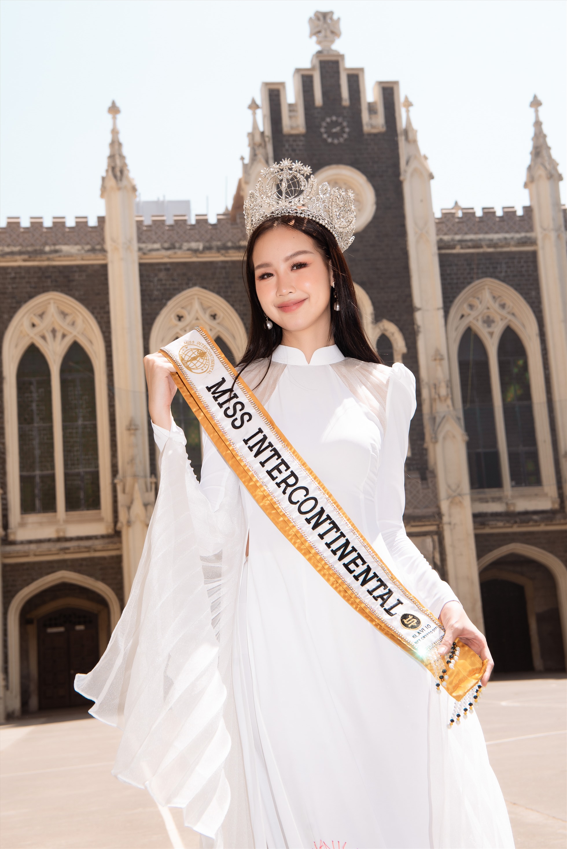 Tạm gác lại những bộ cánh rực rỡ của nàng hậu Quốc tế, Bảo Ngọc lựa chọn chiếc áo dài trắng đơn giản, phần tà xòe rộng mang niềm tự hào văn hoá Việt Nam đến với sinh viên Quốc tế. C