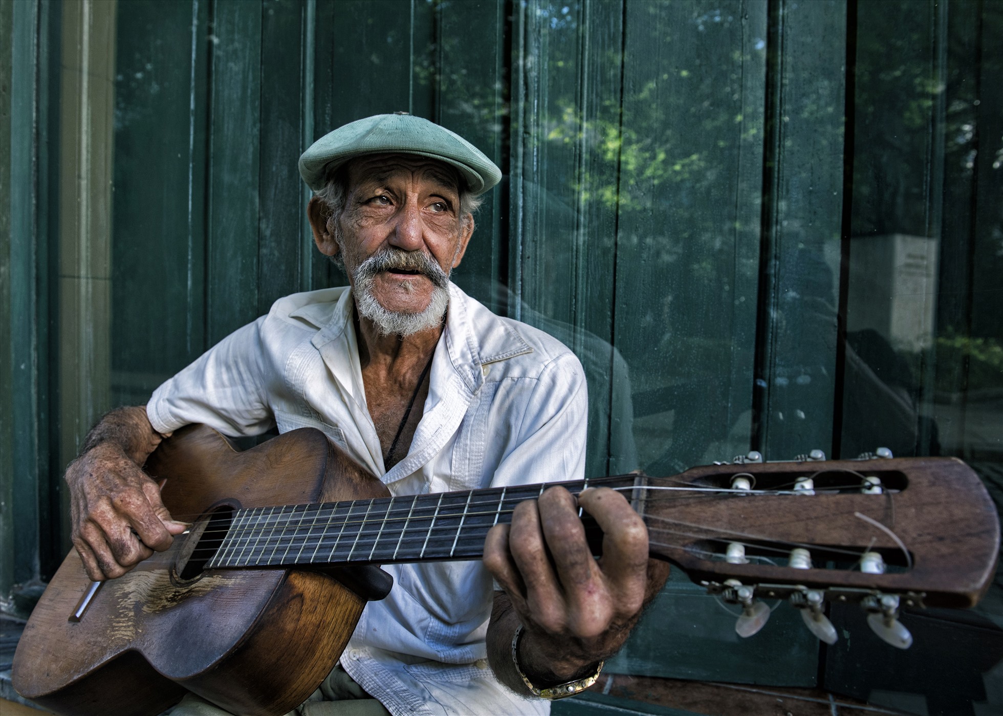 Đôi mắt đượm buồn của ông già chơi đàn guitar trên phố.