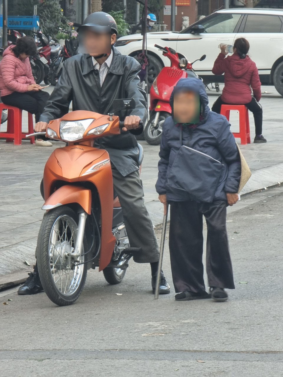 Một người đi xe máy chở bà cụ ăn xin đến khu vực cổng chợ Vinh. Ảnh: Quang Đại