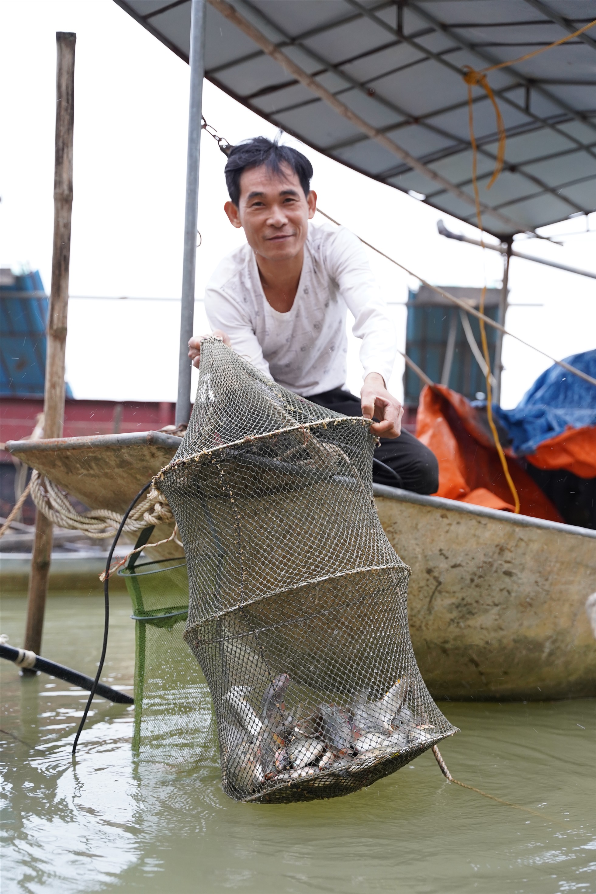 Anh Trần Văn Ngọ (em trai anh Thìn) vui mừng khi hôm nay bắt được nhiều cá. Ảnh: Phạm Thông