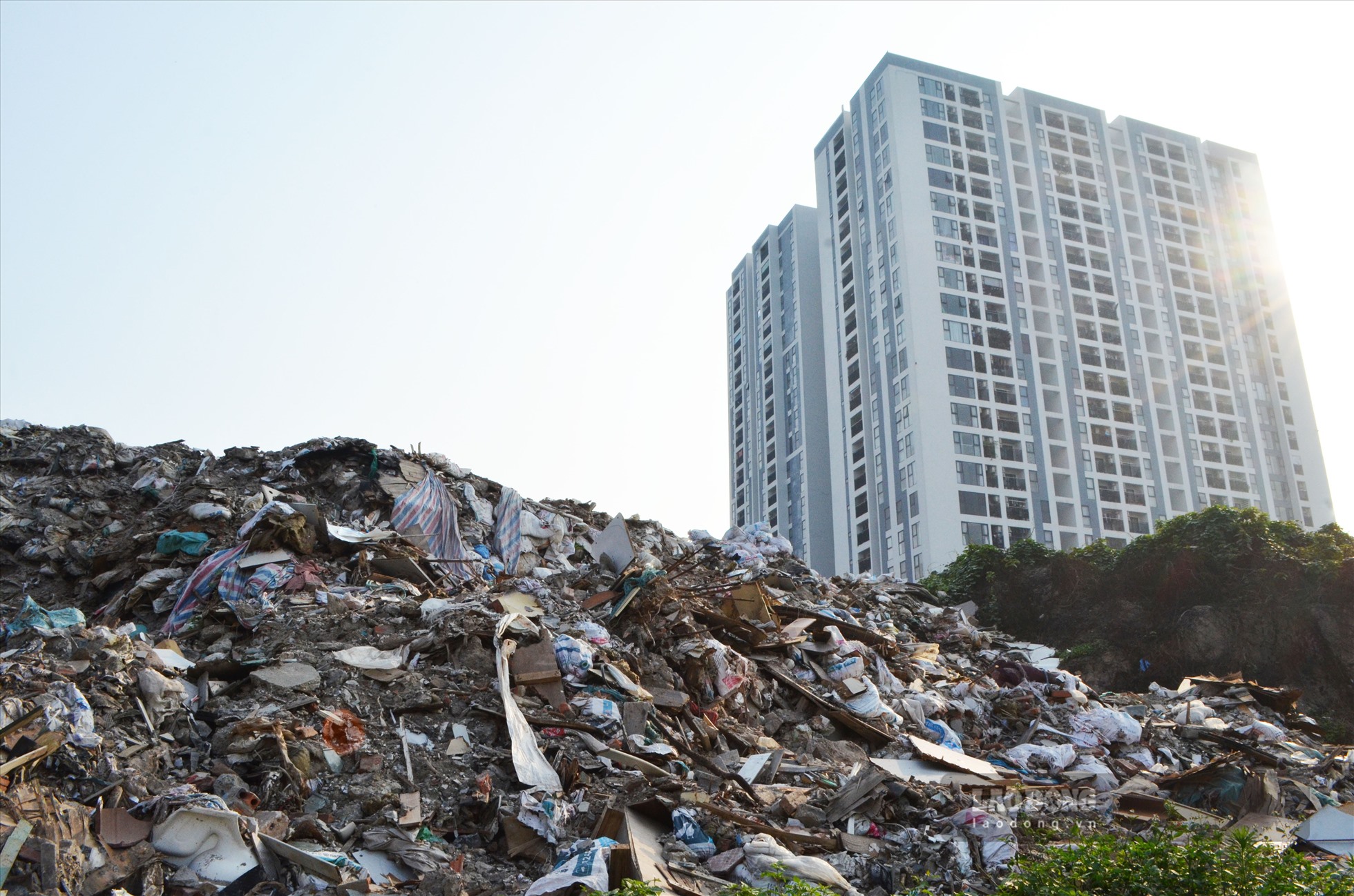 Núi rác cao hàng chục mét với đủ các loại rác thải, bốc mùi hôi thối. Chị Linh, cư dân của tòa nhà cho hay, bãi phế thải đã tồn tại nhiều năm qua. Khói bay cùng mùi khó chịu vào những tòa nhà là điều không thể tránh khỏi.