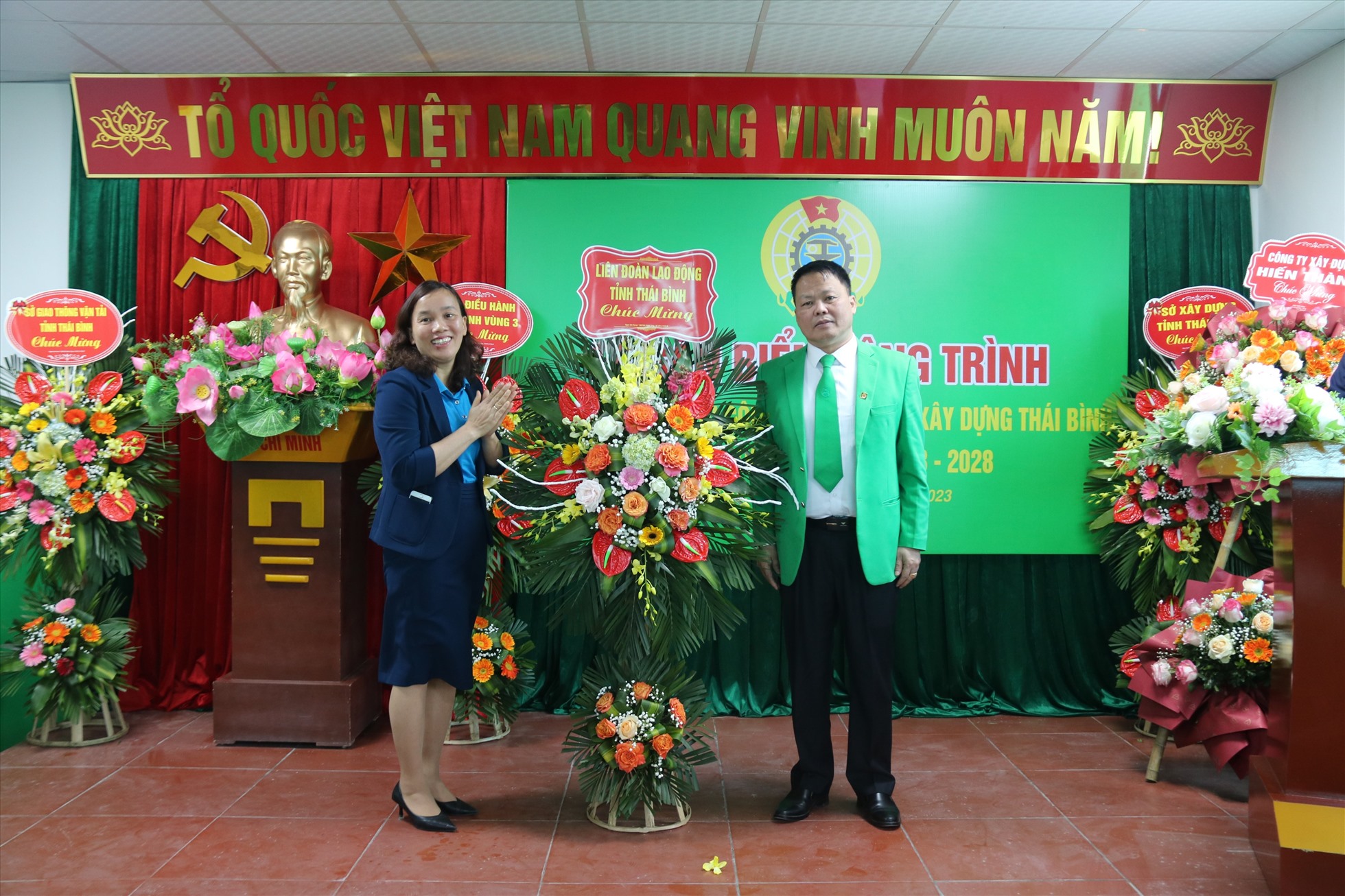 Phó chủ tịch LĐLĐ tỉnh Thái Bình - bà Phạm Thị Thắng tặng hoa chúc mừng đơn vị gắn biển công trình chào mừng Đại hội công đoàn các cấp. Ảnh: Bá Mạnh