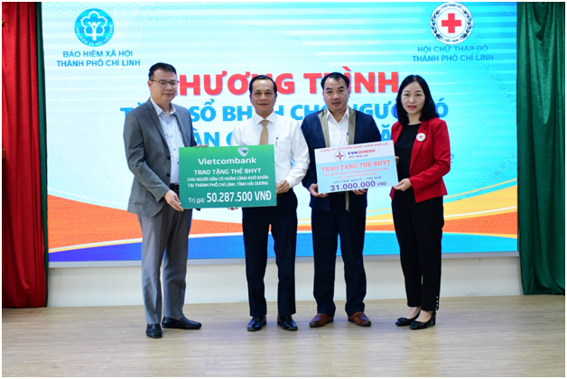 Ông Đặng Kiên Quyết - Phó TGĐ Công ty trao tặng thẻ BHYT cho BHXH TP Chí Linh. Ảnh: Thu Trang