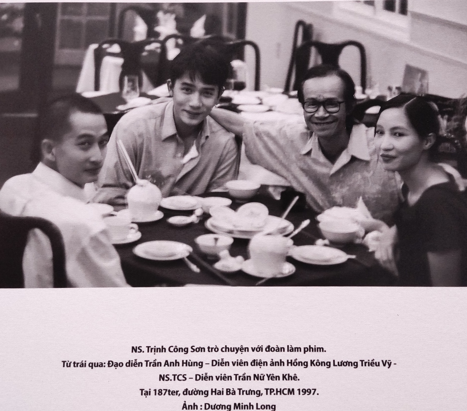 Bức ảnh chụp lại cảnh đạo diễn Trần Anh Hùng, tài tử Lương Triều Vỹ, nhạc sĩ Trịnh Công Sơn và diễn viên Trần Nữ Yên Khê (vợ Trần Anh Hùng) hội ngộ năm 1997 tại TP HCM được trưng bày tại triển lãm. Ảnh: Dương Minh Long