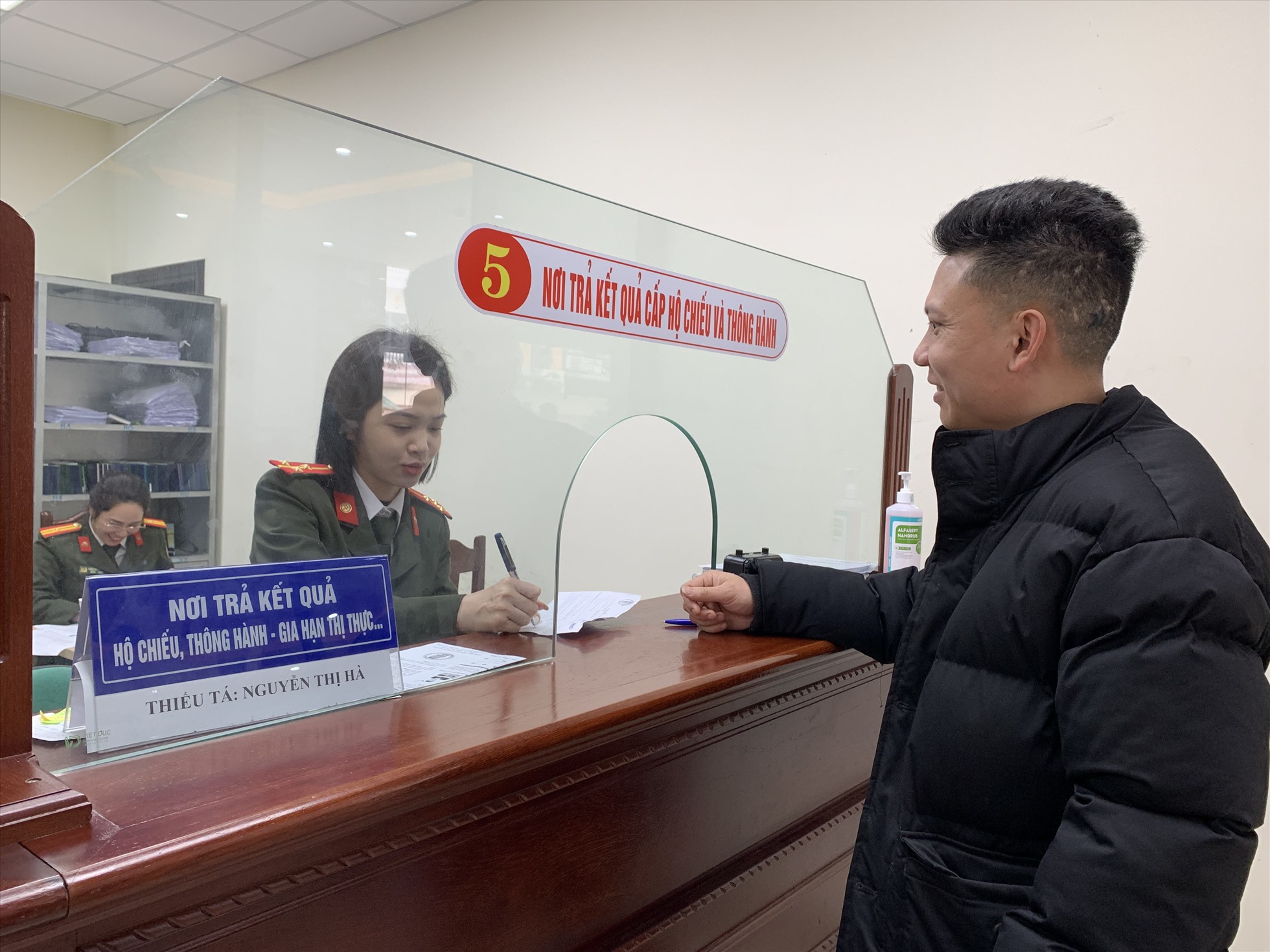 Cán bộ công an trả kết quả hộ chiếu, thông hành- Gia hạn thị thực cho người dân. Ảnh: Quỳnh Trang