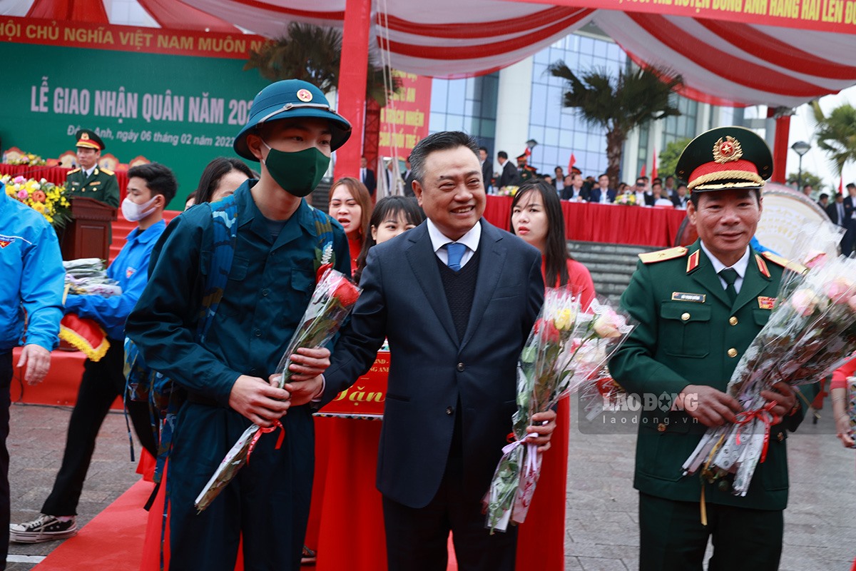 Chủ tịch UBND thành phố, Chủ tịch Hội đồng Nghĩa vụ quân sự thành phố Hà Nội Trần Sỹ Thanh (giữa) cùng lãnh đạo và ban chỉ huy quận sự huyện Đông Anh đã tặng hoa, động viên các tân binh lên đường nhập ngũ.
