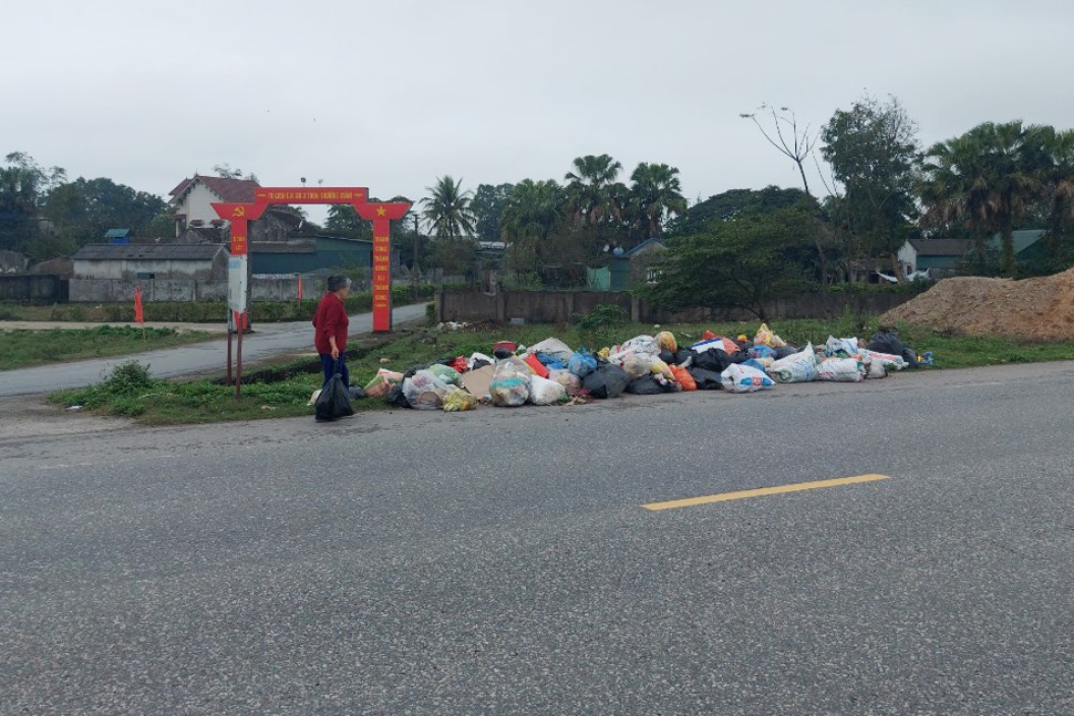 Ban ngày người dân vẫn vô tư đưa rác ra tập kết tự phát trên đường ở thôn Trường Xuân. Ảnh: Trần Tuấn.