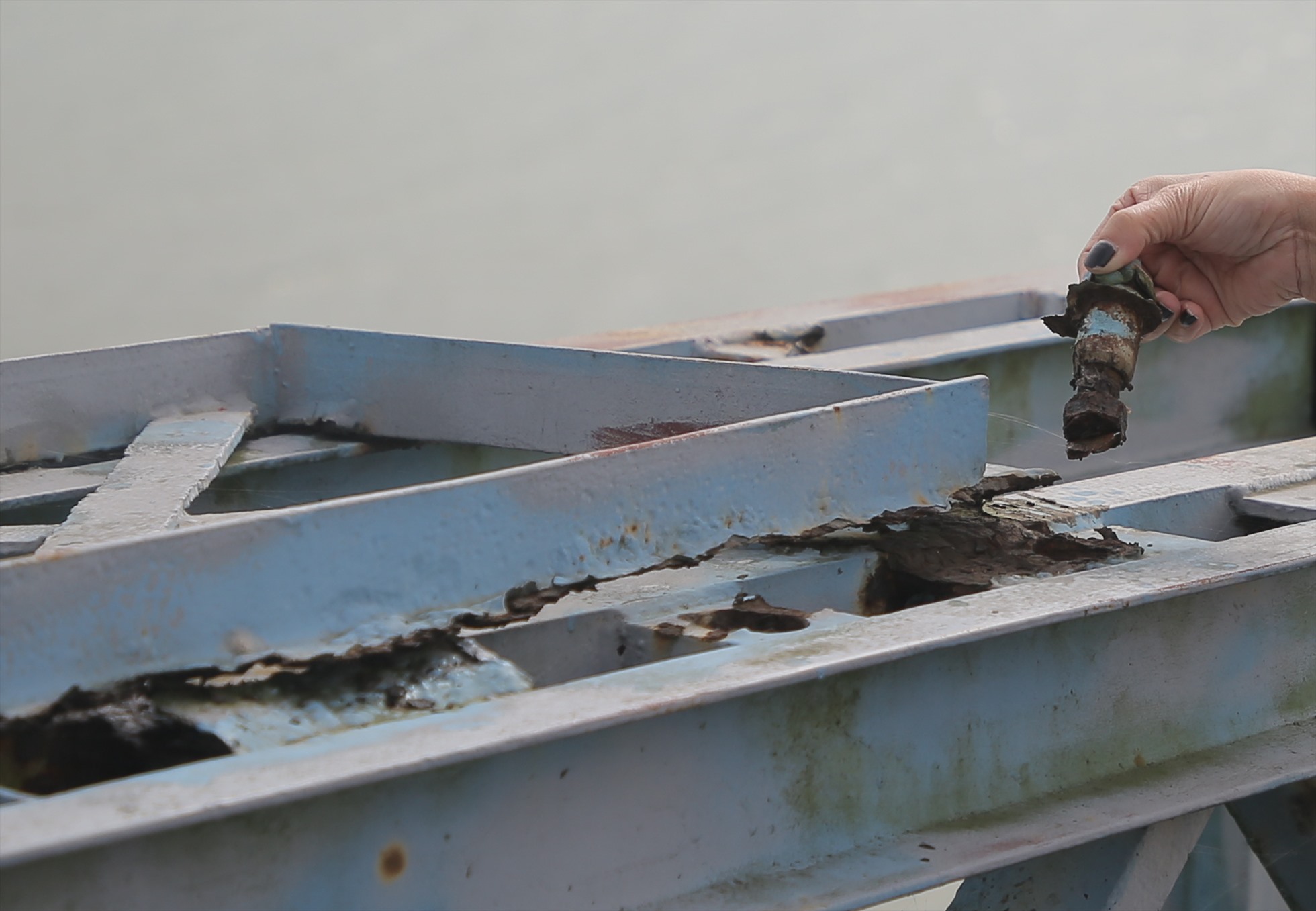 Thanh sắt ở điểm đấu nối trên thành cầu bị gỉ sét đến độ ốc vít thành đồ bỏ đi.