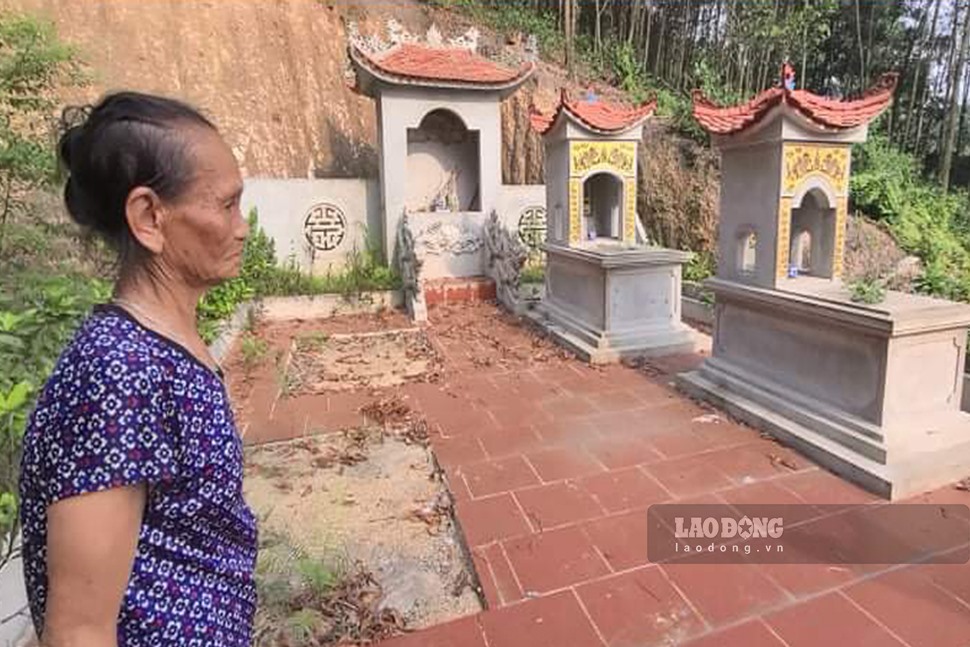 Bà Dương Thị Oanh bên cạnh phần mộ chồng được chôn trên chính mảnh vườn của gia đình. Ảnh: Nguyễn Hoàn.