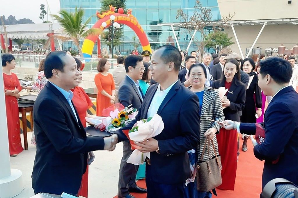 Lãnh đạo huyện Vân Đồn tặng hoa chúc mừng những hành khách đầu tiên tại Cảng cao cấp Ao Tiên. Ảnh: TTTT và VH huyện Vân Đồn