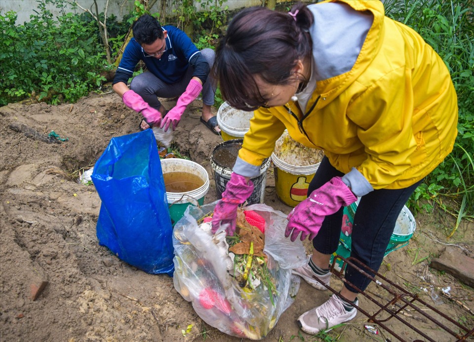 Các tình nguyện viên đang ủ rác hữu cơ để làm phân bón cho cây. Ảnh: Nguyễn Linh